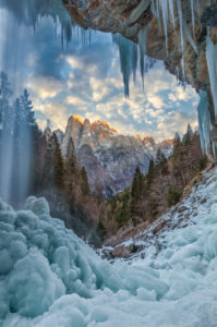 San Lucano valley in Agordino, the waterfall 'dell'Inferno' in winter with the Agner mountain at sunset, Dolomites, Taibon, Belluno, Italy San Lucano valley in Agordino, the waterfall 'dell'Inferno' in winter with the Agner mountain at sunset, Dolomites, Taibon, Belluno, Italy